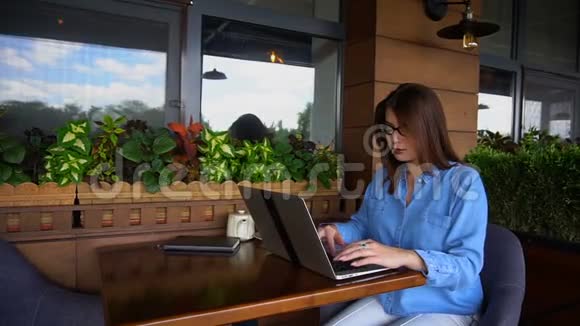 女写手在餐馆用笔记本电脑打字视频的预览图
