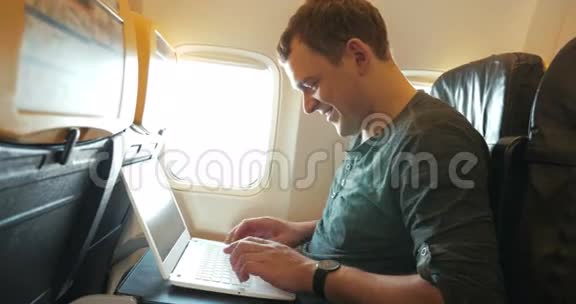 年轻人在飞机上用笔记本电脑聊天视频的预览图