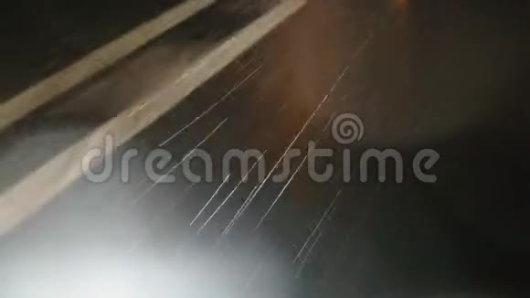 驾驶镜头与安装相机观点在雨天开车穿过夜城夜间射击后视图视频的预览图