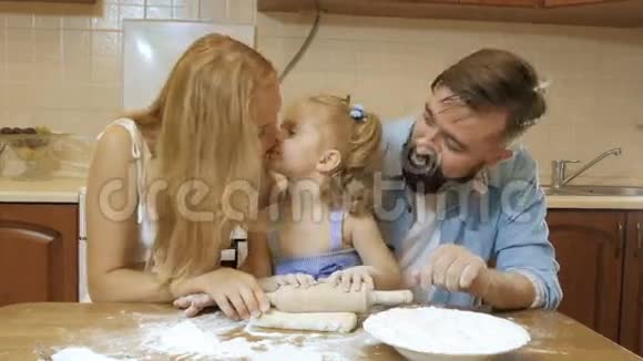 幸福的家庭母亲父亲和小女儿在厨房准备馅饼从测试视频的预览图