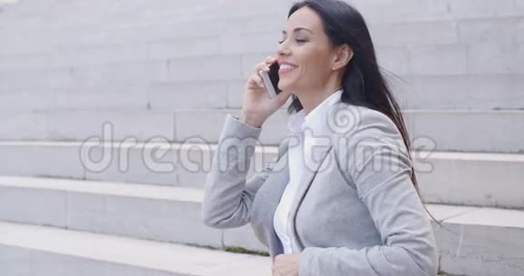 笑的女人坐在台阶上打电话视频的预览图