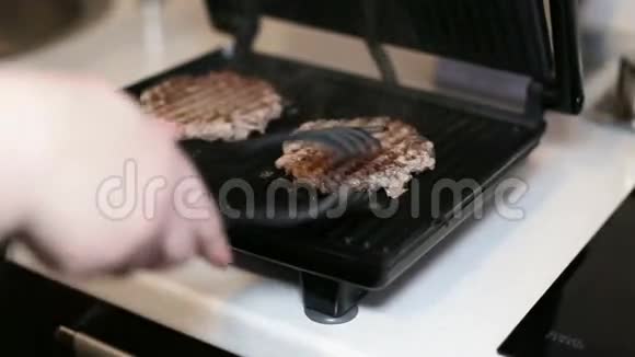 女性手在电烤架上转动牛排特写镜头视频的预览图