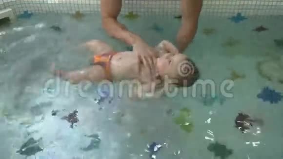 小男孩和爸爸一起在儿童游泳池里游泳视频的预览图