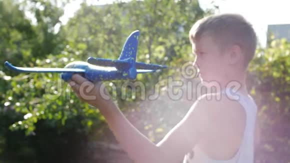 玩得开心快乐男孩与飞机手中的运行日落背景视频的预览图