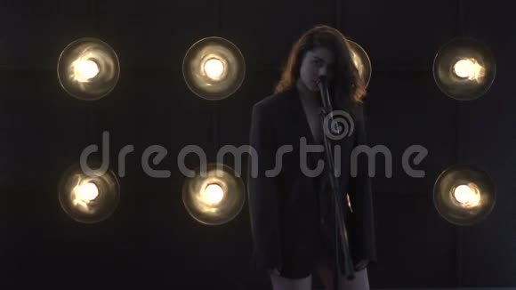年轻漂亮的女孩唱歌年轻歌手唱成麦克风歌手的肖像特写视频的预览图