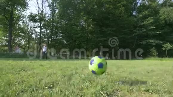 男孩在足球场上踢足球视频的预览图