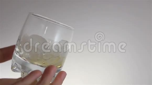 威士忌倒在人手上的玻璃中的冰上视频的预览图