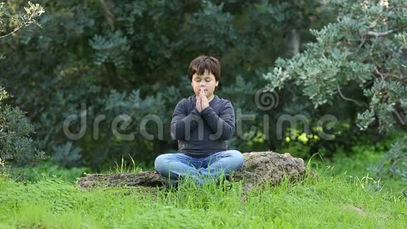 小男孩在户外祈祷和冥想视频的预览图