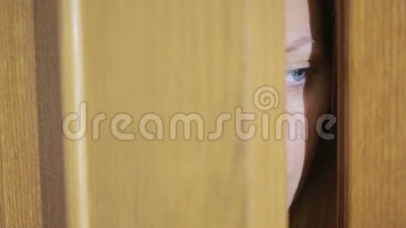 女孩透过门缝探探一只眼睛透过一条缝视频的预览图