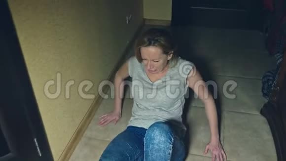 恐怖一个女孩从她的调查员那里爬开掉到她家走廊的地板上视频的预览图