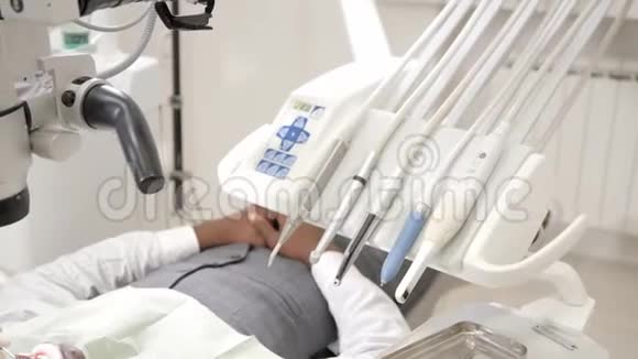 迷人的漂亮女孩医生牙医年轻的非裔美国男性病人在牙科诊所的椅子上医学卫生视频的预览图