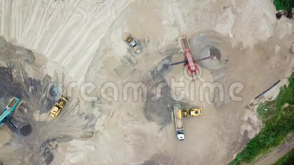 采砂场挖掘机装载机从上面看空中观景翻斗车与货沙车在领土沙厂移动视频的预览图