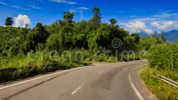 沿弯曲沥青路向森林的摄像机移动视频的预览图