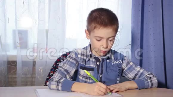 一个男孩在餐桌上做作业的特写镜头视频的预览图