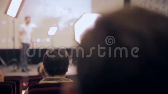 无法辨认的演讲者在会议上得意洋洋听众倾听从观众的背面看视频的预览图