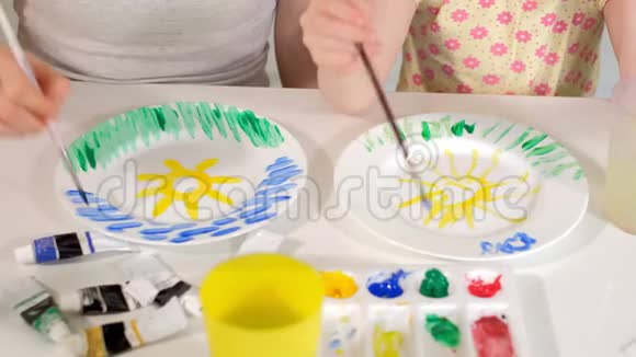 幸福的家庭母亲和小女儿用白色的颜料作画视频的预览图