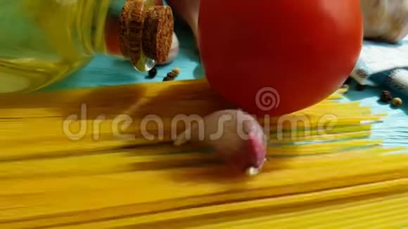 意大利面条手工油配方传统烹饪一瓶美味的慢火大蒜番茄黑胡椒在蓝色木制背景视频的预览图