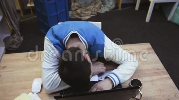 男孩在电脑前睡觉后醒来瞥了一眼床单高兴地伸展学生视频的预览图