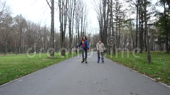 男孩和女孩骑着旱冰车去秋天公园视频的预览图
