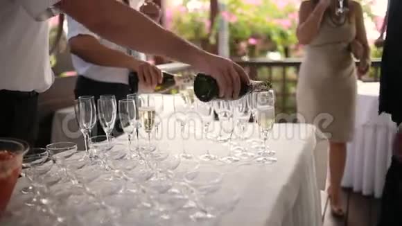 在庆祝活动中优雅的酒杯和香槟酒排在餐桌上服务员倒香槟视频的预览图