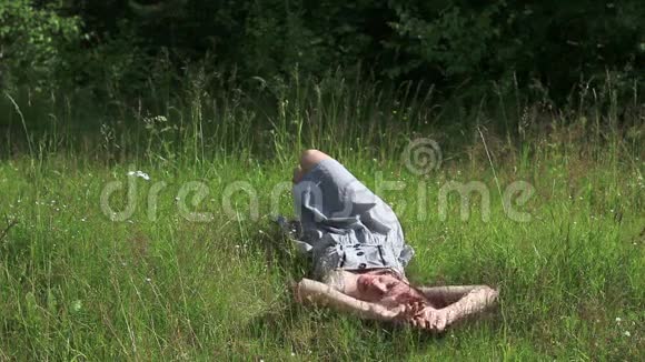 美丽的女孩躺在草地上翻来覆去地看着镜头视频的预览图