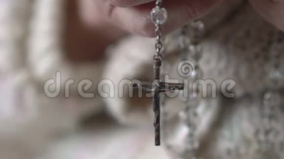 特写十字架和水晶念珠在老手上慢动作视频的预览图