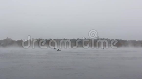 在雾蒙蒙的大雾中乘船捕鱼的渔民视频的预览图