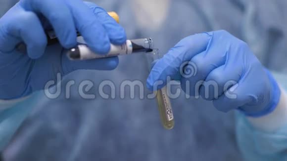 实验室助理正在用黄色液体将绿色液体滴入试管中视频的预览图