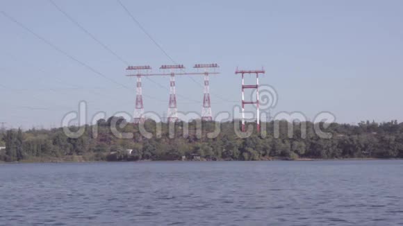 在高压输电塔的背景下摩托艇漂浮在河上视频的预览图