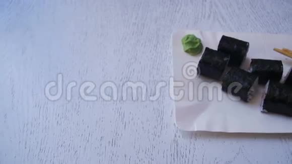 寿司卷与诺丽在日本餐厅的白色时尚木桌上多利射击视频的预览图
