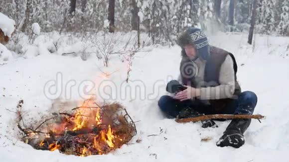 冬季篝火旁温暖的手视频的预览图