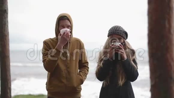 在寒冷的天气里喝酒男人和女人喝热水瓶里的茶视频的预览图