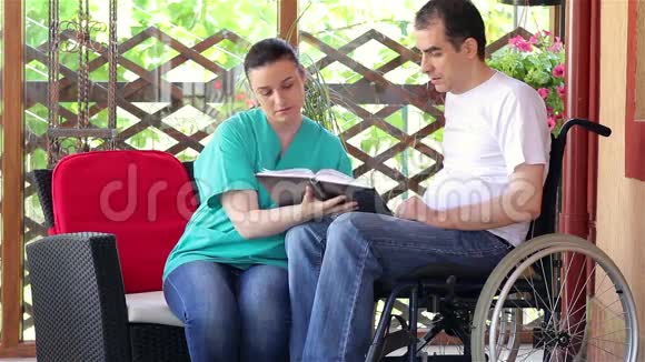 物理治疗师向轮椅上的年轻人讲解练习视频的预览图