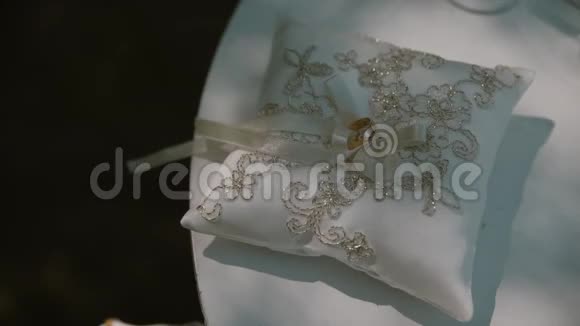 传统白色枕头上的结婚金戒指配对准备举行婚礼视频的预览图