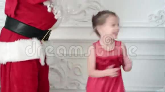 可爱的小女孩和圣诞老人一起跳舞视频的预览图
