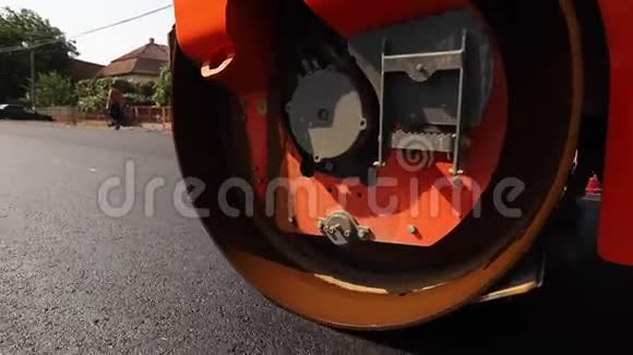 摊铺机在平整的新做道路上搬运夯实整平在修复后的城市道路上铺设沥青的沥青摊铺机视频的预览图