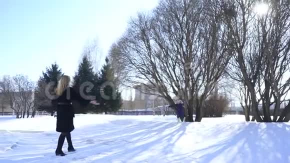 妈妈和女儿在冬季公园散步视频的预览图