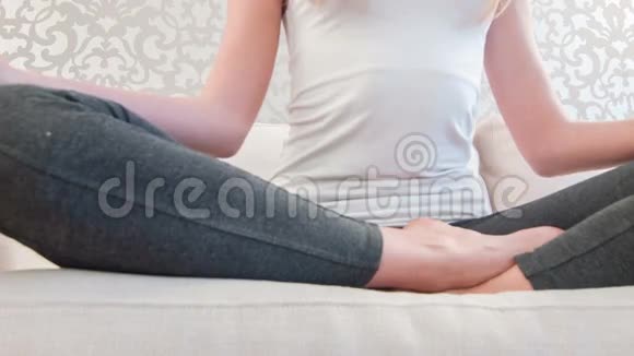 在瑜伽时间坐沙发的漂亮女士视频的预览图