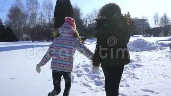 快乐的家庭妈妈和宝贝女儿跑在冬天在雪地里散步玩耍视频的预览图