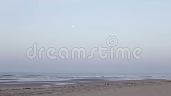 月亮挂在沙滩附近的海面上视频的预览图