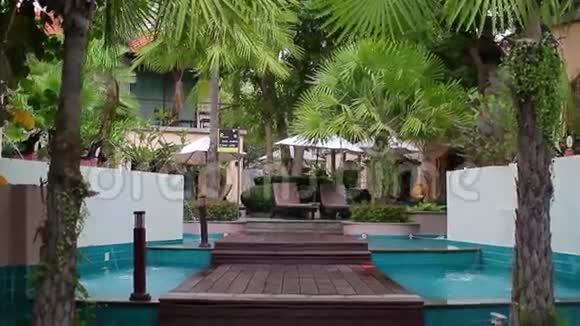 在酒店游泳池附近有棕榈树视频的预览图