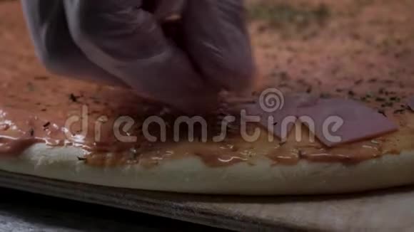 双手准备披萨框架在厨房做饭把配料放在披萨上披萨的概念生产和视频的预览图