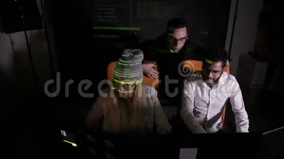 多民族IT专业人员团队在黑暗中与计算机合作黑客攻击计算机系统视频的预览图