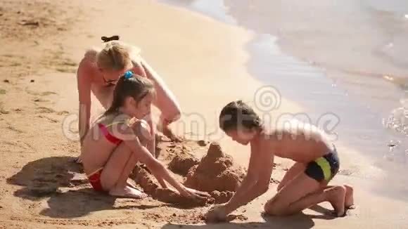 年轻的白人家庭建在沙滩城堡上视频的预览图