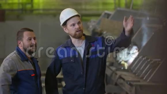 两名建筑工人讨论重工业工厂的施工阶段视频的预览图