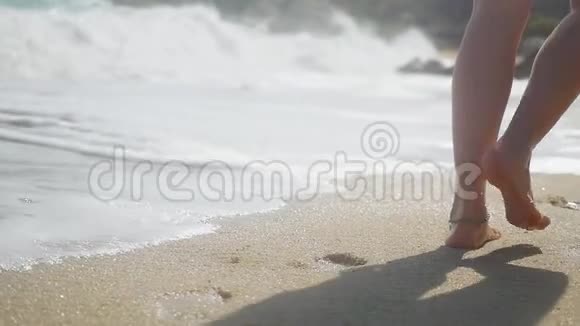 女人的脚戴着手镯在热带海滩上行走缓慢地在沙滩上留下脚印1920x1080视频的预览图
