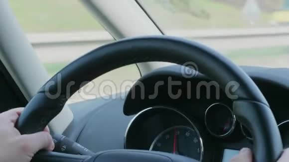 白天高速公路汽车行驶时双手方向盘视频的预览图