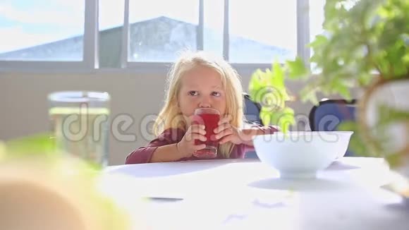 小金发女郎在白桌上吃果汁视频的预览图