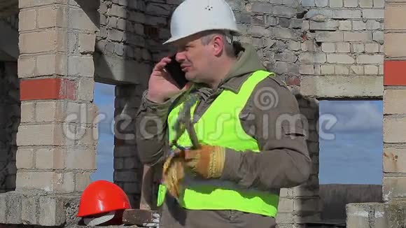 有手机手推车和木槌的建筑工人视频的预览图