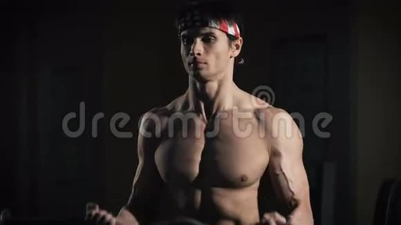 一个肌肉男在健身房用杠铃锻炼的特写镜头视频的预览图